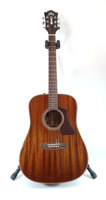 a close up of a guitar on a stand against a white background