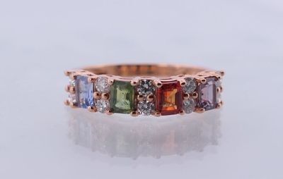 un gros plan sur une bague en or rose sertie de pierres multicolores