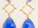 a pair of blue glass earrings with gold accents