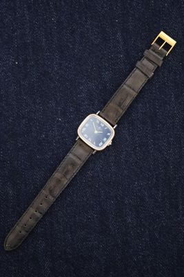 a close up of a watch on a blue surface