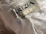 the label on a white dress is on the back of a woman ' s dress