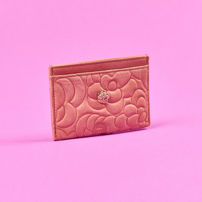 un porte-cartes rose posé sur une surface rose