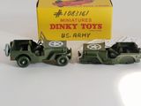 two toy army vehicles in front of a box