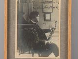 an old photo of a man sitting in a chair with a book