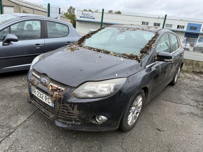 une voiture noire recouverte de feuilles