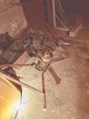 un tas de vieilleries par terre, à côté d'une voiture jaune