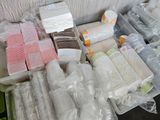 many rolls of toilet paper, toilet paper, and other items in plastic containers