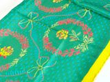 a close up of a green and yellow sari with yellow border