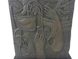 statue of a person holding a knife in front of a wall