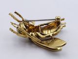 a gold brooch with skis and skis on it