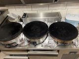 trois casseroles posées sur une cuisinière dans une cuisine