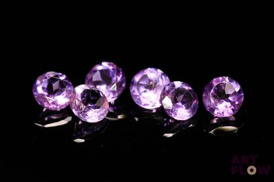 purple amethorate gems in a row on a black surface