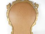 an antique brass mirror with a wooden frame on a white background