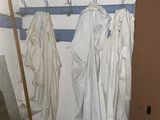 an image of a dirty bathroom with clothes hanging on the wall