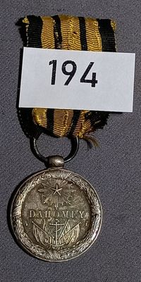 a gold medal with a black and yellow ribbon around it