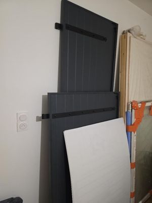une porte noire sur laquelle est fixée une ardoise blanche