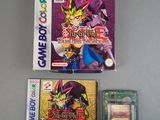 two gameboy games and a card case on a table