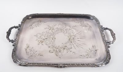 un plateau ancien en argent orné de motifs floraux sur fond blanc