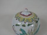 a white vase with a bird on it on a table