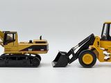 two toy construction vehicles that are on a white surface
