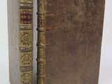 un vieux livre à la couverture brune posé sur une surface blanche