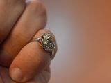 a person holding a diamond ring in their hand
