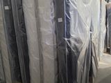 many mattresses wrapped up in plastic in a warehouse