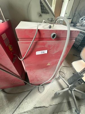 un réfrigérateur rouge posé au milieu d'une pièce
