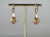 a close up of a pair of earrings on a stand