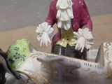 a figurine of a man in a boat with a bird on it