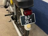 a yellow and black motorcycle parked next to a blue and white wall