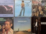 many different album covers on the wall of a room
