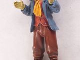 une figurine représentant un homme portant un chapeau et une écharpe