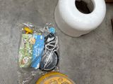 a roll of toilet paper and some other items on the floor
