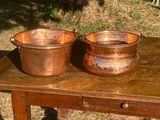 deux casseroles en cuivre posées sur une table en bois