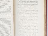 an open book sitting on top of a white table next to a cup of coffee