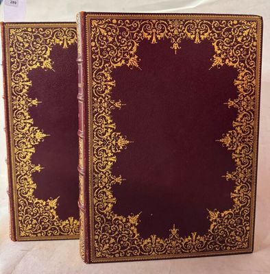 deux livres ornés de motifs dorés, posés sur une surface blanche
