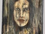 an oil painting of a woman ' s face on a wooden panel