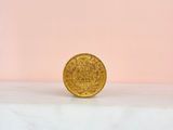a gold coin sitting on top of a marble slab
