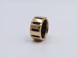 a close up of a gold ring with black stripes on it