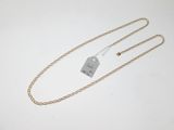 une chaîne en or à laquelle est accrochée une médaille, posée sur une surface blanche