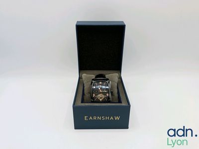 une image représentant une montre dans un écrin noir posé sur une surface blanche