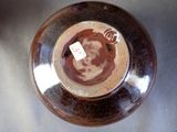 a brown vase with a tag on it on a table