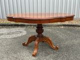 a wooden table sitting on top of a sidewalk next to a building