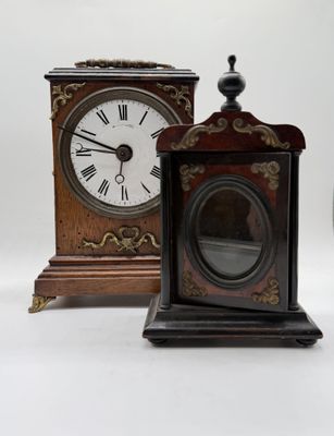 two clocks sitting next to each other on a white surface