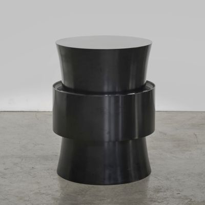 une table d'appoint noire avec un piètement circulaire et un plateau rond