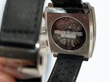 a person holding a watch in their hand on a white surface