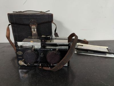 an old camera sitting on top of a table next to a bag