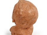 a clay sculpture of a man ' s head on a white surface