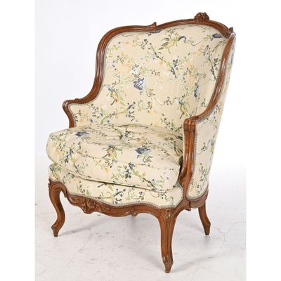 a chair with a floral upholstered back and a wooden frame